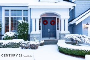 Picture of blue home in the winter with snow